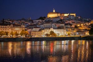 Coimbra illuminated, night, University on hilltop, rower, Mondego River, Portugal Coimbra illuminated, night, University on hilltop, rower, Mondego River, Portugal