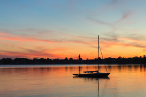 Segelboot bei Sonnenuntergang auf dem Chiemsee, Riemsting, Oberbayern, Deutschland Segelboot bei Sonnenuntergang auf dem Chiemsee, Riemsting, Oberbayern, Deutschland
