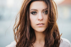 Young, attractive, brunette woman in front of blurred background, summer mood, good weather, looking at camera, portrait Young, attractive, brunette woman in front of blurred background, summer mood, good weather, looking at camera, portrait