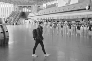 Eine junge Reisende mit Mundschutz durchquert die fast menschenleere Abflugshalle des Terminal 1 am Frankfurter Flughafen, während des allgemeinen Lockdowns in Deutschland wegen der Corona Pandemie. Eine junge Reisende mit Mundschutz durchquert die fast menschenleere Abflugshalle des Terminal 1 am Frankfurter Flughafen, während des allgemeinen Lockdowns in Deutschland wegen der Corona Pandemie.