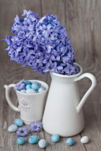 Hyacinth flowers in vase and Easter eggs in coffee cup, still life Hyacinth flowers in vase and Easter eggs in coffee cup, still life