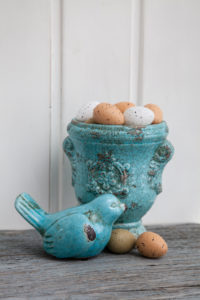 Easter still life, Easter eggs in ceramic pot and bird figure, close-up, still life Easter still life, Easter eggs in ceramic pot and bird figure, close-up, still life