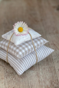 Daisies on pile of pillows, Bellis perennis, close-up, still life Daisies on pile of pillows, Bellis perennis, close-up, still life