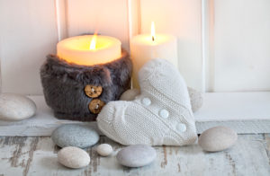 rustic Christmas or autumn still life with candles, knitted heart and pebble across white wood rustic Christmas or autumn still life with candles, knitted heart and pebble across white wood