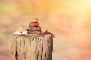 stone cairn on wooden ole at sunset in warm sunlight stone cairn on wooden ole at sunset in warm sunlight
