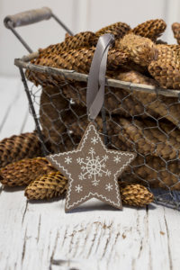 rustic Christmas still life with vintage wire basket full of pine cones and wooden star ornament rustic Christmas still life with vintage wire basket full of pine cones and wooden star ornament