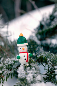 colorful traditional Christmas tree decorations made of wood arranged on a snowy fir branch colorful traditional Christmas tree decorations made of wood arranged on a snowy fir branch