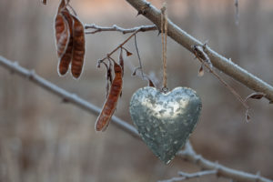 simple tin heart ornament hanging outside on a cold autumn day simple tin heart ornament hanging outside on a cold autumn day