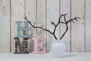 decoration in a white interior with wooden letters of word home and simple twigs in a vase decoration in a white interior with wooden letters of word home and simple twigs in a vase