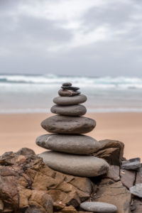 well balanced stone cairn on a lonely beach at the wild west coast of the portuguese algarve well balanced stone cairn on a lonely beach at the wild west coast of the portuguese algarve