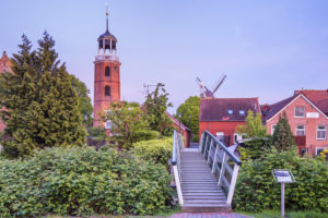 Backsteinkirche und Fußgängerbrücke von Ditzum, Fischerdorf an der Unterems in Ostfriesland, Rheiderland, Niedersachsen, Norddeutschland, Deutschland, Europa Backsteinkirche und Fußgängerbrücke von Ditzum, Fischerdorf an der Unterems in Ostfriesland, Rheiderland, Niedersachsen, Norddeutschland, Deutschland, Europa