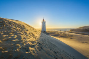 Lighthouse and Dune Rubjerg Knude with Sun, Løkken, Lokken, North Jutland, Denmark Lighthouse and Dune Rubjerg Knude with Sun, Løkken, Lokken, North Jutland, Denmark
