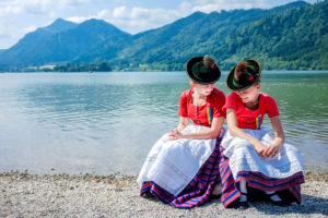Two girls in traditional costumes of Schliersee on the shore of Lake Schliersee at the annual church day Two girls in traditional costumes of Schliersee on the shore of Lake Schliersee at the annual church day