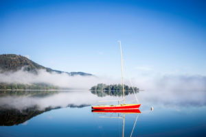 Sailboat on the Schliersee in Fischhausen in the morning fog Sailboat on the Schliersee in Fischhausen in the morning fog