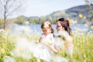 Mother and child on a flowering meadow, the child picks flowers Mother and child on a flowering meadow, the child picks flowers