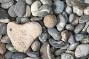 Heart-shaped stone on pebble beach Heart-shaped stone on pebble beach