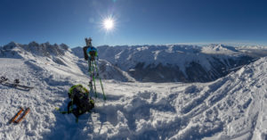 Ski tourer at the finish. Ski and touring equipment in front of sun with sun star, mountain station, snow. Ski tourer at the finish. Ski and touring equipment in front of sun with sun star, mountain station, snow.