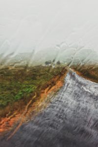 Rain runs down a car window, country road in Ireland Rain runs down a car window, country road in Ireland