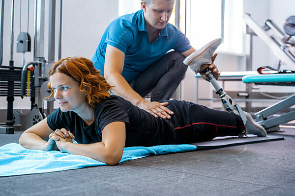 Group of fit seniors on treadmills working out in gym, man smiling