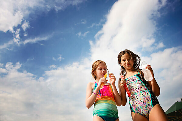 Three Teenage Girls (16-17) Wearing Bikinis Pictured Against Sky