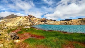 Blue lake in volcano crater with green and red grass, Tongariro Crossing in New Zealand Blue lake in volcano crater with green and red grass, Tongariro Crossing in New Zealand