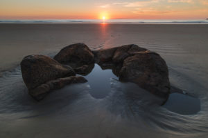 Broken stone ball of the Moeraki Boulders on the beach at sunrise, Koekohe Beach, New Zealand Broken stone ball of the Moeraki Boulders on the beach at sunrise, Koekohe Beach, New Zealand