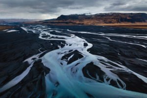 Aerial view of a branched river course with the Eyjafjallajökull massif and Seljalandsfoss in the background, Suderland, Iceland Aerial view of a branched river course with the Eyjafjallajökull massif and Seljalandsfoss in the background, Suderland, Iceland