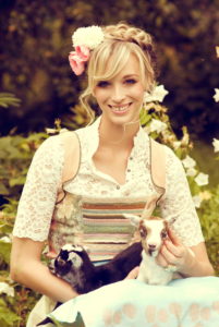 Blond woman, dirndl, meadow, sitting, happy, smiling, holding young goat in her arms, Blond woman, dirndl, meadow, sitting, happy, smiling, holding young goat in her arms,