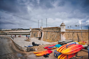 Europe, Portugal, Algarve, Litoral, Barlavento, Felsalgarve, District Faro, Lagos, Forte Ponta da Bandeira, with colorful kayaks in the foreground Europe, Portugal, Algarve, Litoral, Barlavento, Felsalgarve, District Faro, Lagos, Forte Ponta da Bandeira, with colorful kayaks in the foreground