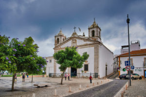 Europe, Portugal, Algarve, Litoral, Barlavento, Felsalgarve, Faro District, Lagos, Praca do Infante Dom Henrique, Igreja de Santa Maria Church, former resting place of Henry the Navigator, blooming jacaranda trees Europe, Portugal, Algarve, Litoral, Barlavento, Felsalgarve, Faro District, Lagos, Praca do Infante Dom Henrique, Igreja de Santa Maria Church, former resting place of Henry the Navigator, blooming jacaranda trees