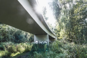 Architecture, technology and nature, under a bridge, superstructure against the light, sun spot with rays of light, vegetation on the banks of the Ilmenau, Lower Saxony, Architecture, technology and nature, under a bridge, superstructure against the light, sun spot with rays of light, vegetation on the banks of the Ilmenau, Lower Saxony,
