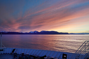 Cruise on the coast of Norway, sunset over the sea, dramatic sky coloring