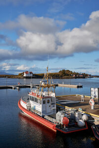 Cruise on the coast of Norway, Vega Archipelago, Bronnoysund, cabin cruiser in the harbor of the town of Brønnøysund at the center of the Norwegian coast, sunny weather, portrait format