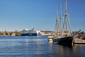 Cruise on the coast of Norway, harbor of the city of Oslo, traditional sailing ship at the quay, in the background the ferry Color Line of the Kiel-Oslo line