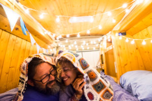Couple in love and relationship have fun during a travel vacation with an old restored van to tiny house - van life concept for modern trendy people enjoying the freedom and the minimalism lifestyle Couple in love and relationship have fun during a travel vacation with an old restored van to tiny house - van life concept for modern trendy people enjoying the freedom and the minimalism lifestyle
