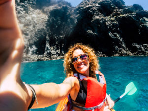 Cheerful people happy smiling female take selfie picture with kayak having outdoor leisure sport activity in the blue ocean water - concept of hapiness in summer holiday vacation Cheerful people happy smiling female take selfie picture with kayak having outdoor leisure sport activity in the blue ocean water - concept of hapiness in summer holiday vacation