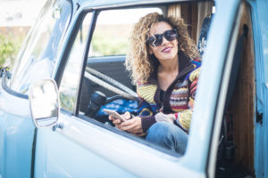 Blonde woman sits in a blue bus and smiles at the camera Blonde woman sits in a blue bus and smiles at the camera