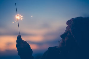 close up of woman looking at sparkler the night of the new year at the evening alone and lonely - lady playing with sparkler outdoors close up of woman looking at sparkler the night of the new year at the evening alone and lonely - lady playing with sparkler outdoors