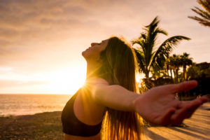 Healthy people lifestyle enjoying sunset and fitness activity alone - beautiful woman feel the sun and the ocean oxygen after workout sport session class - open arms and freedom breathe Healthy people lifestyle enjoying sunset and fitness activity alone - beautiful woman feel the sun and the ocean oxygen after workout sport session class - open arms and freedom breathe