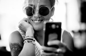 Black and white beautiful adult caucasian alernative trendy woman portrait - cheerful and smile lady with tatto doing selfie picture or video call with mobile phone Black and white beautiful adult caucasian alernative trendy woman portrait - cheerful and smile lady with tatto doing selfie picture or video call with mobile phone