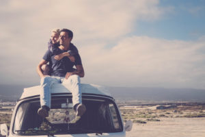 Love and travel with romantic wanderlust young people couple hug and stay together on an old vintage van rooftop enjoying romance and relationship - alternative tourist vacation lifestyle Love and travel with romantic wanderlust young people couple hug and stay together on an old vintage van rooftop enjoying romance and relationship - alternative tourist vacation lifestyle