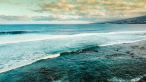 Aerial oceanand coastline view - sea water and surf waves and sky with clouds at the horizon in background - tourism and coast scenic place for vacation Aerial oceanand coastline view - sea water and surf waves and sky with clouds at the horizon in background - tourism and coast scenic place for vacation