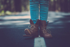 Concept of travel lifestyle for free people - money related concept and close up of woman legs with broken shoes on the road - walk and enjoy the adventure with asphalt and defocused background Concept of travel lifestyle for free people - money related concept and close up of woman legs with broken shoes on the road - walk and enjoy the adventure with asphalt and defocused background