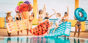 Group of caucasian friends have fun at the pool in summer holiday vacation - females people together playing with lilos and blue water at hotel resort - cheerful females laugh and smile Group of caucasian friends have fun at the pool in summer holiday vacation - females people together playing with lilos and blue water at hotel resort - cheerful females laugh and smile