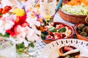 Close up of table full of fresh seasonal healthy food for group of people - lunch or brunch background coloured composition Close up of table full of fresh seasonal healthy food for group of people - lunch or brunch background coloured composition