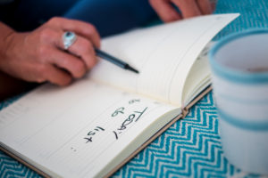 New change life project concept with lose up of woman writing the to do list on a notebook paper - white page ready to start - focus on blocks New change life project concept with lose up of woman writing the to do list on a notebook paper - white page ready to start - focus on blocks