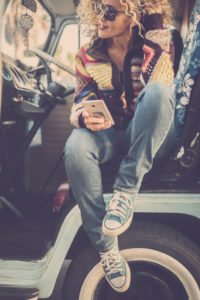 Smiling woman enjoying her road trip. Beautiful female wearing warm clothing and driving a van. Independent adult female enjoy travel alone with minivan retro style Smiling woman enjoying her road trip. Beautiful female wearing warm clothing and driving a van. Independent adult female enjoy travel alone with minivan retro style