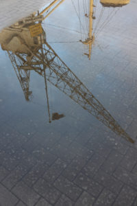old cranes in the museum harbor reflecting in a puddle old cranes in the museum harbor reflecting in a puddle