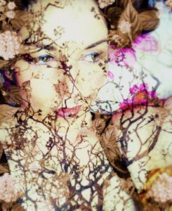 Portrait of a woman overlaid with branches and flowers,