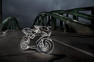 light drawing of a racing moto radian on a bridge at night,